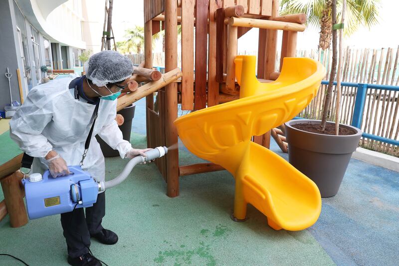 Cleaning staff disinfecting the play area.