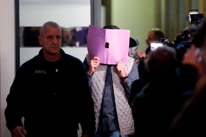 One of the defendants, Wayci R., hides his face behind a folder as he arrives at a court in Berlin for the opening of the trial over the theft of the so-called "Big Maple Leaf" golden coin from the Bode-Museum last year. AFP