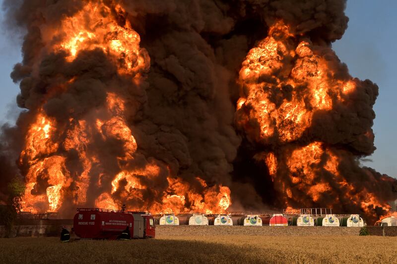 Firefighters try to douse intense flames and smoke at an oil terminal in Nowshera, Pakistan. AFP