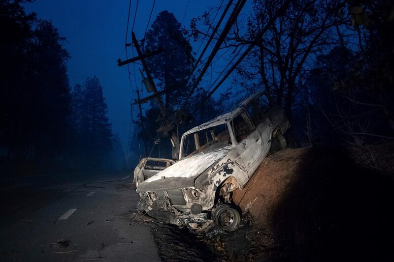 A scorched vehicle rests on a roadside. AP Photo
