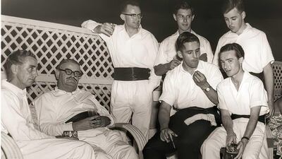 Dr Desmond McCaully, who started Al Maktoum Hospital in 1951, seen here seated, second left, in Dubai in 1959.  The men are wearing what was known as "Gulf rig", a dress code that maintained formality with a white shirt and cummerbund, but dispensed with a dinner jacket and bow tie due to the heat. 