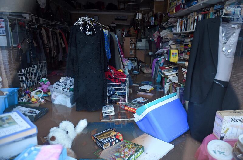 Items float in flood water inside a flooded charity shop in Tenbury Wells, after the River Teme burst its banks in western England.  AFP