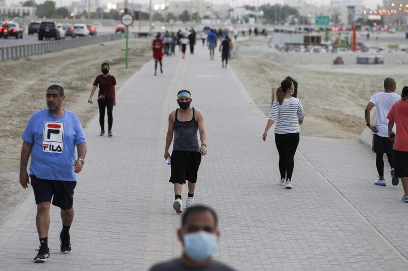 People walk along a path amid the coronavirus outbreak, in Manama, Bahrain.  Reuters