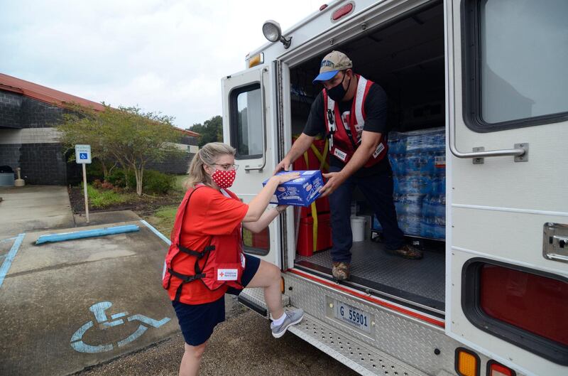 American Red Cross volunteers Cindy Romig and Cliff Boyer unload supplies outside the Pike County Community Safe Room storm shelter in Magnolia, Mississippi, ahead of Hurricane Delta's landfall.  AP