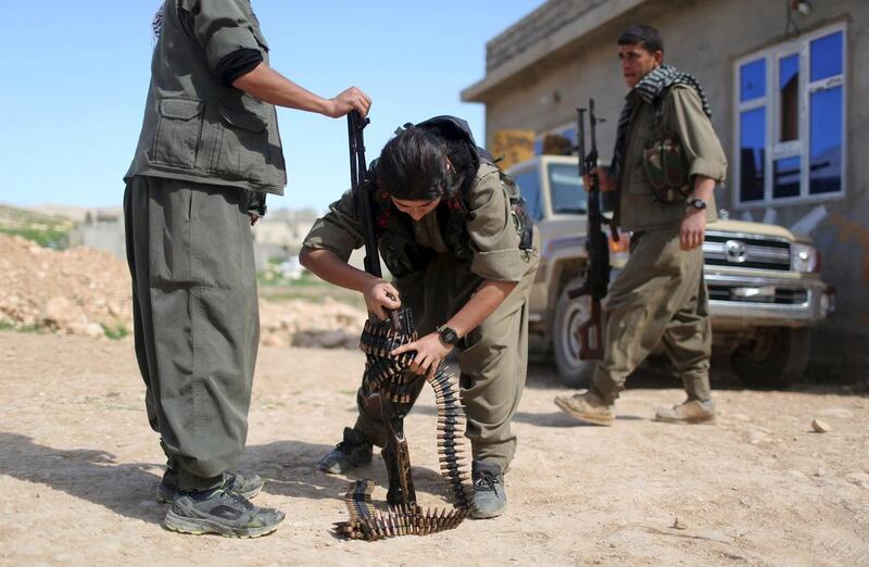 A PKK fighter adjusts a machinegun in preparation to join others near a site hit by ISIL car bombs in Sinjar. Asmaa Waguih / Reuters