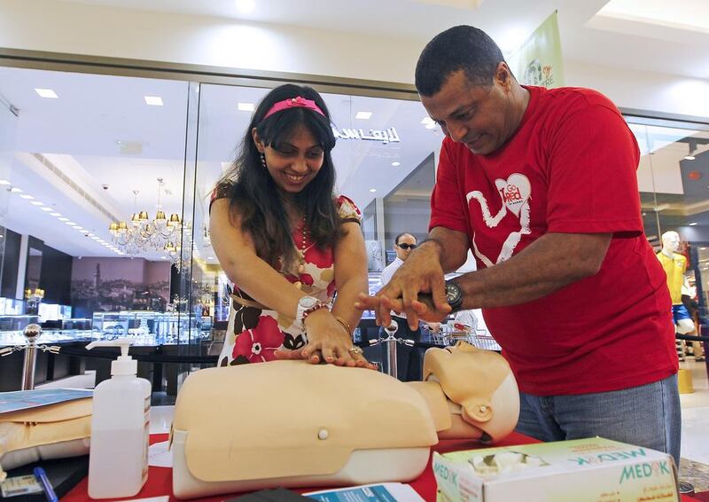Sally Samy and Boubaker Beltaief, an instructor in CPR, during a lesson at a Sharjah mall organised by Go Red for Women. Jeffrey E Biteng / The National
