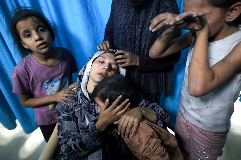 A wounded Palestinian woman is surrounded by her children at Nasser Hospital in Khan Younis after Israeli air strikes hit their home. AFP