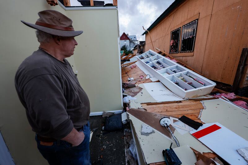Mel Gilmer surveys the damage to his business in Selma. AP