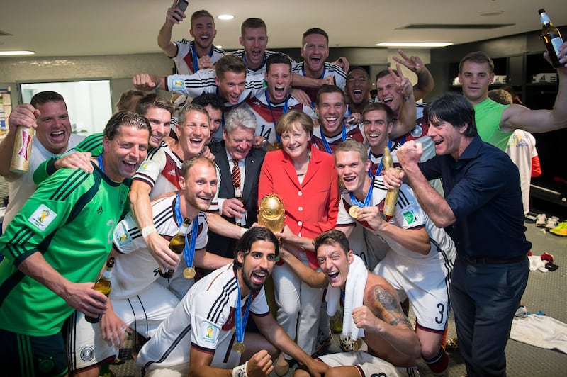 Mrs Merkel and German President Joachim Gauck celebrate with the German national football team after its 1-0 victory in the 2014 FIFA World Cup Brazil Final match against Argentina in 2014. Getty Images
