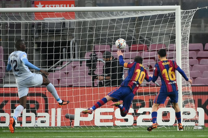Lionel Messi heads the ball to score Barcelona's first goal against Valencia. AFP