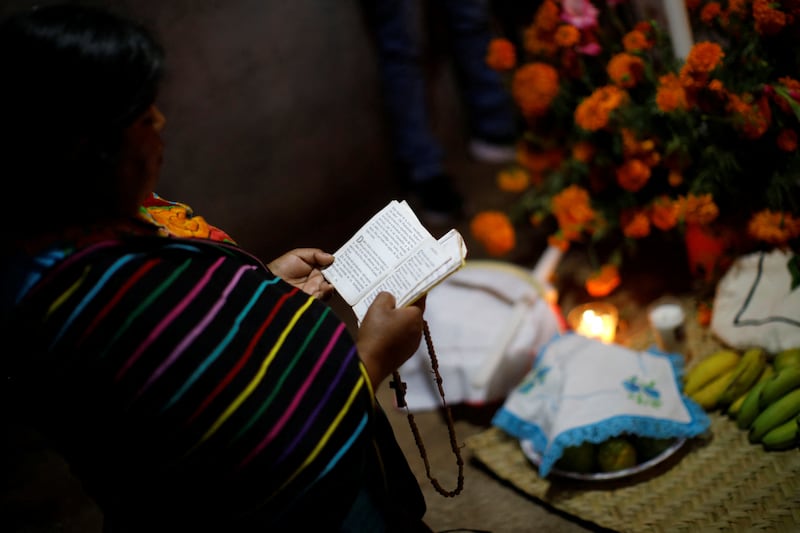 A woman prays in front of an altar in homage to a person who died recently. Reuters