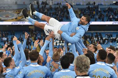 Manchester City players hold striker Sergio Aguero aloft during celebrations after winning the Premier League. AFP
