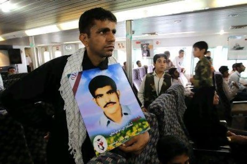 An Iranian man holds a portrait of his brother who was killed when a US warship shot down Iran Air flight 655 in 1988.