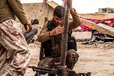 A fighter of the US-backed Syrian Democratic Forces loads an ammunition belt at a position in the village of Baghouz near Syria's border with Iraq. AFP