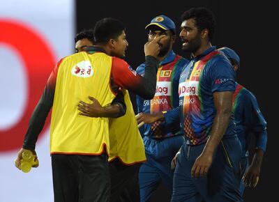 Bangladesh's Nurul Hasan (L) exchanges words with Sri Lanka's skipper Thisara Perera (R) during the sixth Twenty20 (T20) international cricket match between Bangladesh and Sri Lanka of the tri-nation Nidahas Trophy at the R Premadasa stadium in Colombo on March 16, 2018. / AFP PHOTO / ISHARA S.  KODIKARA