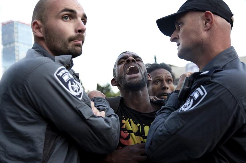 Israeli police officers detain an Ethiopian protester during a demonstration in Tel Aviv on Sunday. Tsafrir Abayov / AP Photo