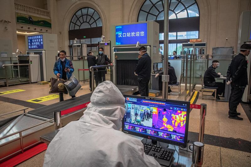Passengers go through the security and body temperature check at the railway station after the lockdown was lifted in Wuhan, China.  EPA