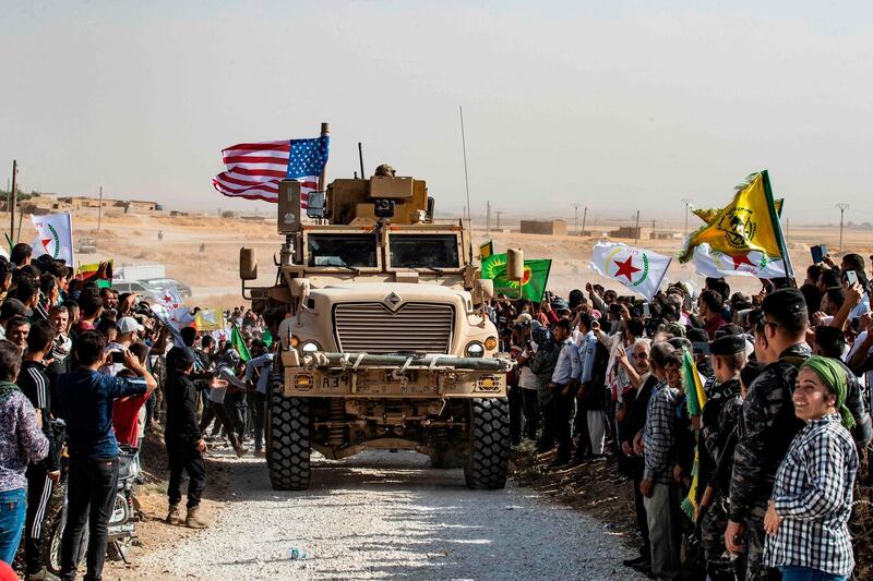 Syrian Kurds gather around a US armoured vehicle during a demonstration against Turkish encroachment. AFP