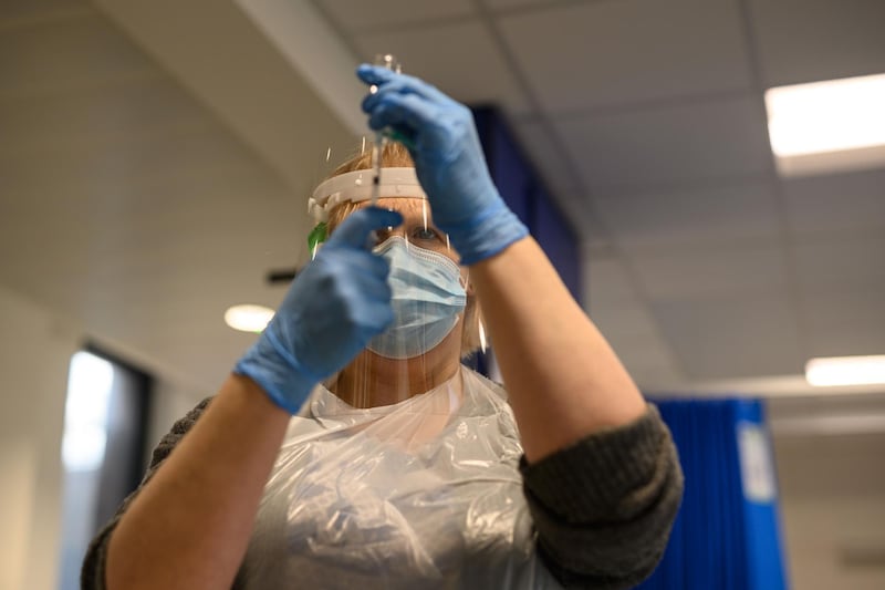 A volunteer draws a solution into a syringe as she practices intramuscular injections during vaccinator training to prepare volunteers to be deployed to assist in the national Covid-19 vaccination programme, in the Allam Medical Building at the University of Hull, northern England, on January 30, 2021.  The University of Hull started training vaccinators to support the UK's Covid-19 vaccination programme. The NHS is in the process of deploying thousands of volunteers to increase the roll-out of vaccinations across the UK in the fight against Covid-19 with eight million people having already received at least one vaccine jab in what is the country's largest ever innoculation programme. / AFP / OLI SCARFF
