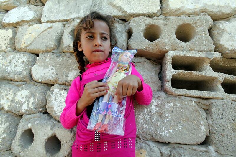Heba Alwadiya, 6, holds a toy she received from her grandfather Salih, a tradition for the festival of Eid Al Adha. Adel Hana / AP

