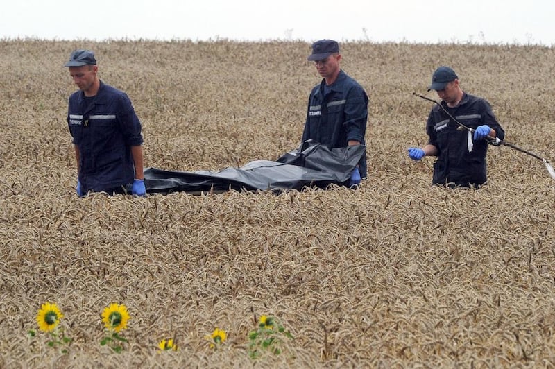 Ukrainian rescue workers carry the body of a victim on a stretcher through a wheat field at the site of the crash of Malaysia Airlines plane MH17 that was shot down on Thursday. Emergency workers say that rebels have removed the bodies from the crash site. Dominique Faget/AFP Photo