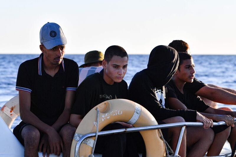 Tunisians trying to flee to Europe sit aboard a Tunisian coast guard vessel after being intercepted at sea on August 10, 2023. AFP