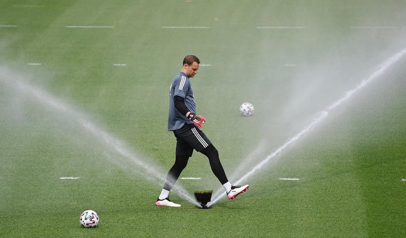 Goalkeeper Manuel Neuer stands next to a sprinkler. AP