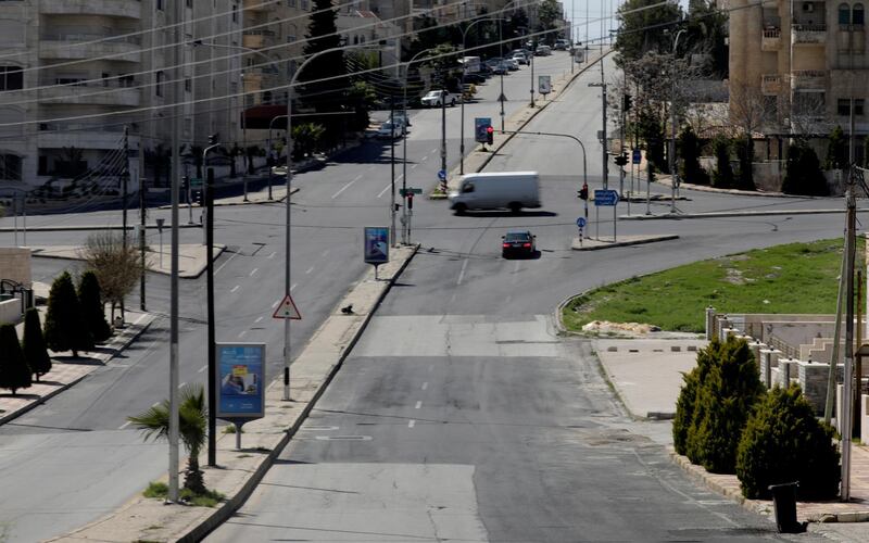 Two vehicles in a deserted street in Amman, Jordan.  EPA