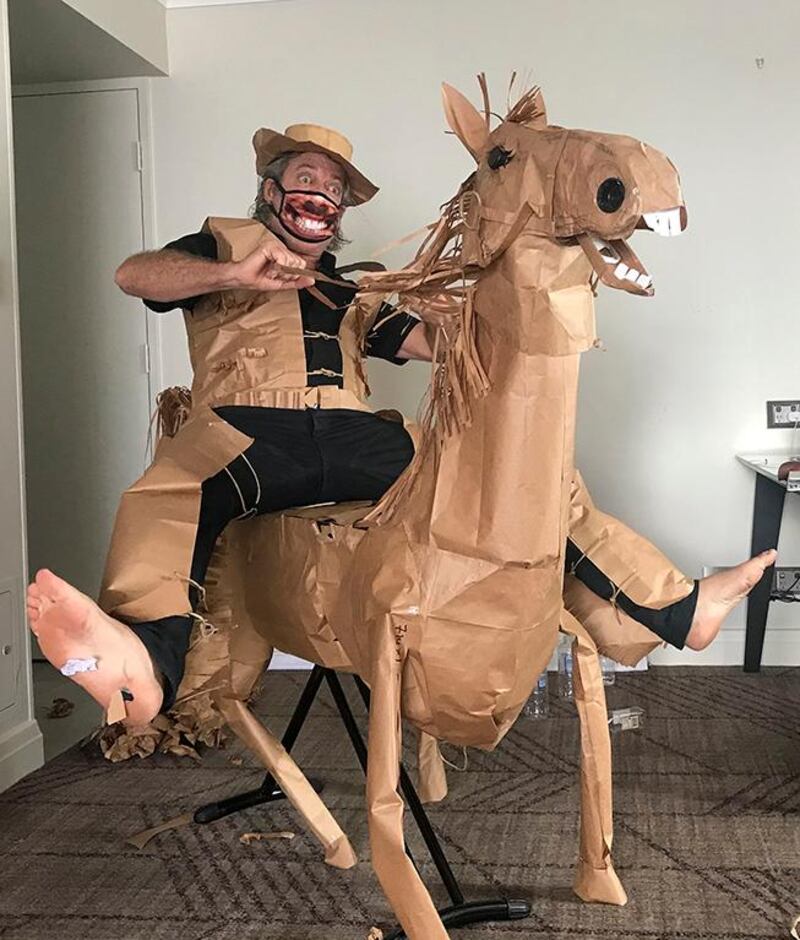 David Marriott poses with his paper horse in his hotel room in Brisbane, Australia, April 1, 2021. While in quarantine inside his Brisbane hotel room, art director Russell Brown was bored and started making a cowboy outfit from the paper bags his meals were being delivered in. His project expanded to include a horse and a clingfilm villain that he has daily adventures with, in images that have gained a huge online following. (David Marriott via AP)