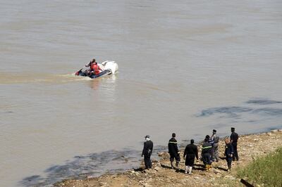 Iraqi civil defence recover a body from the Tigris river in the northern Iraqi city of Mosul on May 16, 2018.  Some 10 months after dislodging the Islamic State group, fire crews and police are still extracting bodies from the ruins of the shattered Old City. / AFP / Waleed AL-KHALID
