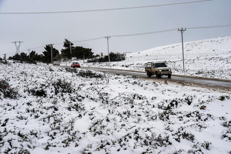 Vehicles drive along a road amidst snow in the Sidi al-Hamri region of Libya's eastern Jebel Akhdar (Green Mountain) upland region, about 200 kilometres east of Benghazi, on February 16, 2021. (Photo by - / AFP)