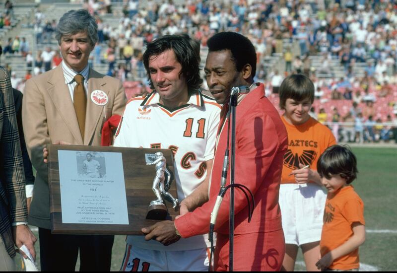 Pele is presented with the Greatest Football Player Trophy by George Best, before an American League match between Aztecs and New York Cosmos at the Rose Bowl, in Los Angeles, April 1987. Reuters