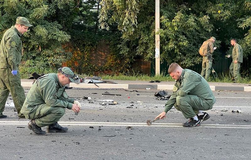 Investigators at the scene of a car bomb that killed Darya Dugina outside Moscow. Photo: Investigative Committee of Russia / AP