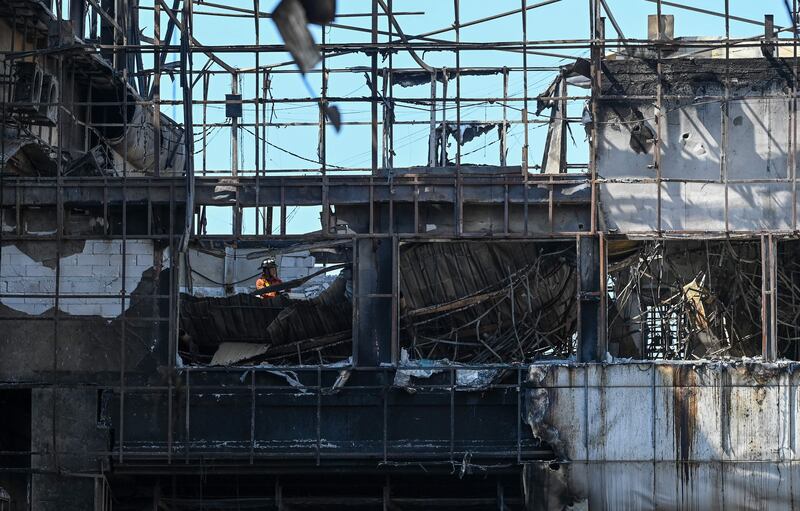 Rescuers scour the charred ruins of the hotel. AFP