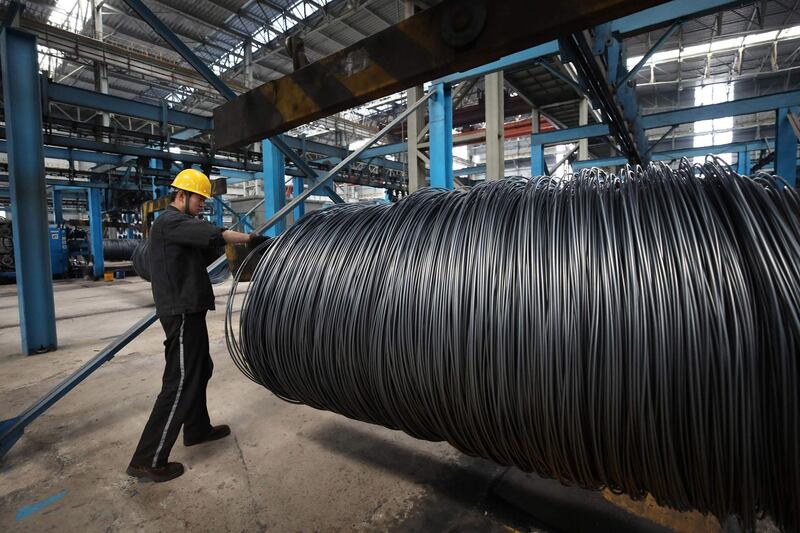 (FILES) This file photo taken on May 1, 2018 shows a worker handling steel cable at a steel factory in Lianyungang, in China's eastern Jiangsu province.  China on June 15, 2018 swiftly retaliated by imposing "equal" tariffs on US products following a decision by US President Donald Trump to slap duties on $50 billion of Chinese products. / AFP / -
