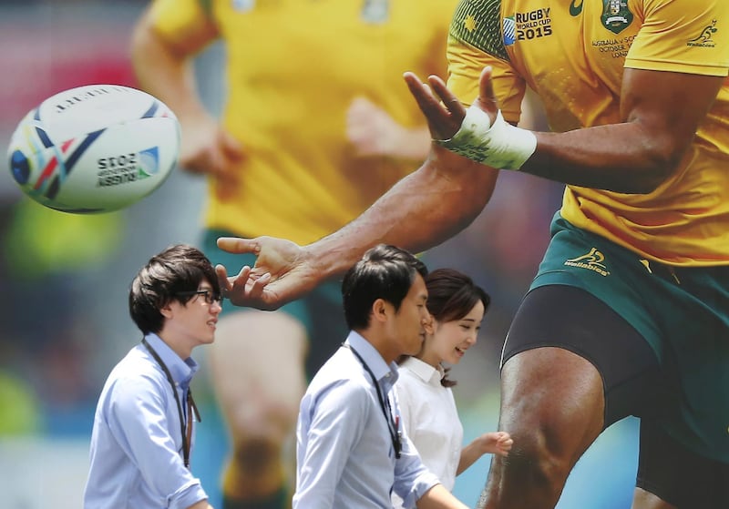 People walk past a photo displaying the promotion of the Rugby World Cup, in Tokyo, Japan. AP Photo