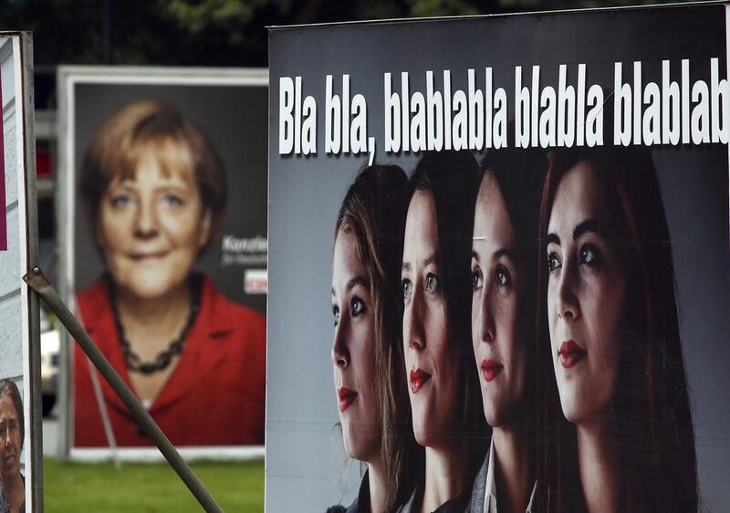 Election campaign posters of the German Christian Democratic party promoting Angela Merkel, left, and of the satirical party Die Partei (The Party), right, in Berlin on Friday. Michael Sohn / AP Photo