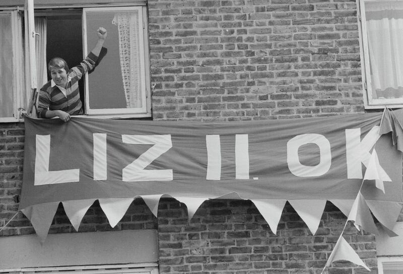 Vic Hiscoke, looking out a window, shows his banner, which says 'Liz II OK', on the occasion of the Silver Jubilee of Queen Elizabeth II, UK, 3rd June 1977. (Photo by Evening Standard/Hulton Archive/Getty Images)