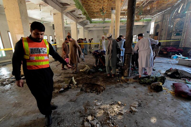 Rescue workers collect remains at the site of a blast in a religious school in Peshawar.  AFP