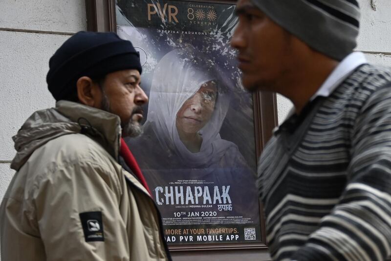 Pedestrians walk past a poster for the Bollywood movie Chhapaak in New Delhi on January 10, 2020.  / AFP / Money SHARMA
