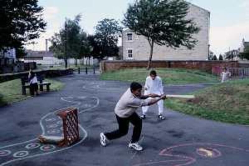 ca. 2001, Manningham, Bradford, West Yorkshire, England, UK --- Asian children play cricket in a park in Manningham, an area where primarily Asian Muslims live. --- Image by © Gideon Mendel/CORBIS