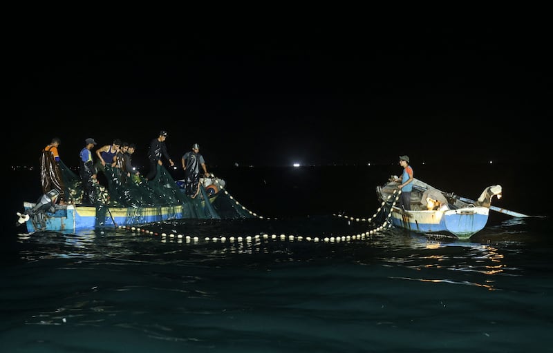 Palestinian fishermen lift their net during a fishing  mission off the coast of Gaza city. All photos: AFP