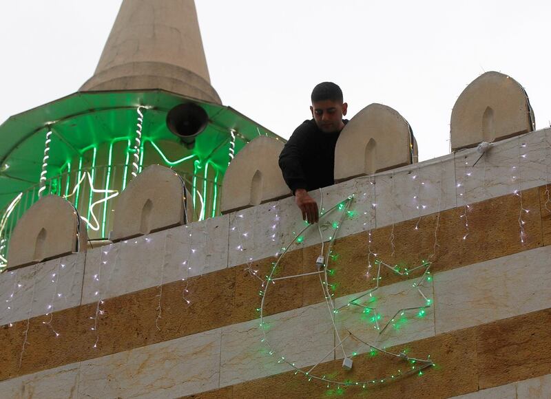 A man hangs decorations ahead of the Muslim holy month of Ramadan on a mosque during a countrywide lockdown over the coronavirus disease (COVID-19) in Beirut, Lebanon. Reuters
