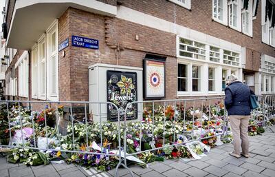 A passer-by looks at the flowers that have been deposited outside the office of the shot lawyer Derk Wiersum. - Derk Wiersum, defence lawyer in a major gangland drugs case was shot dead outside his Amsterdam home on September 18, 2019, raising fresh fears that the Netherlands is turning into a "narco-state". (Photo by Koen van Weel / ANP / AFP) / Netherlands OUT