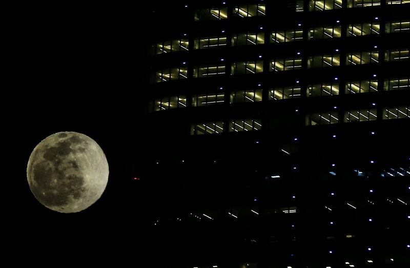 The wolf moon, the first moon of the year rises behind Al-Hamra tower in Kuwait City, on January 28, 2021. / AFP / YASSER AL-ZAYYAT
