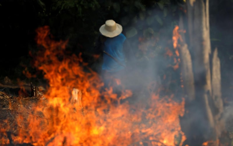 A man works in a burning tract of Amazon jungle as it is being cleared by loggers and farmers in Iranduba, Amazonas state, Brazil.  Reuters