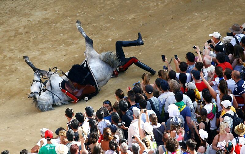 An Italian Carabinieri police falls down from his horse during their parade prior the Palio di Siena. Stefano Rellandini / Reuters