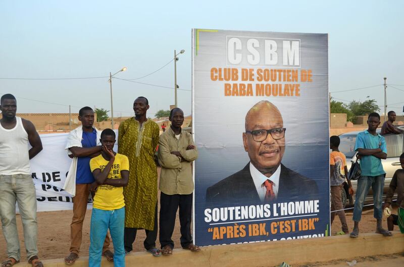 TOPSHOT - Supporters of Malian incumbent president Ibrahim Boubacar Keita wait at the Gao stadium on July 18, 2018 for a presidential campaign rally. / AFP / Souleymane Ag Anara
