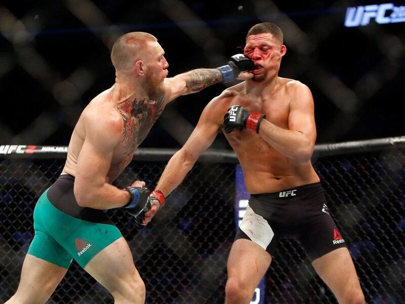 Conor McGregor, left, hits Nate Diaz with a left during their welterweight rematch at UFC 202. AFP