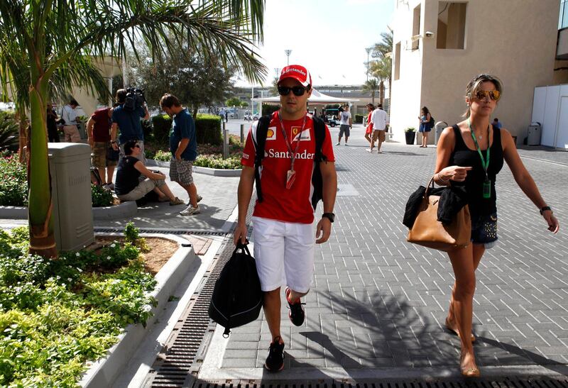 Ferrari Formula One driver Felipe Massa of Brazil arrives with his wife Anna Rafaela Bassi in the paddock ahead of the Abu Dhabi F1 Grand Prix at the Yas Marina circuit in Abu Dhabi November 10, 2011. REUTERS/Ahmed Jadallah (UNITED ARAB EMIRATES - Tags: SPORT MOTORSPORT) *** Local Caption ***  ABD18_MOTOR-RACING-_1110_11.JPG
